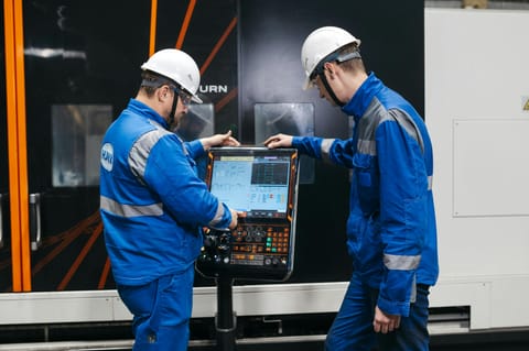 Trabajadores operando panel CNC